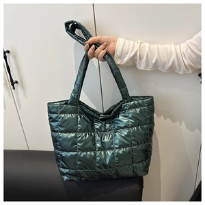 Detailed shot of dark green quilted tote bag with a high-gloss metallic finish