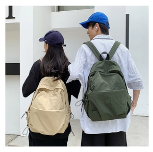 Detail of minimalist nylon backpack in khaki and dark green showing water-resistant fabric