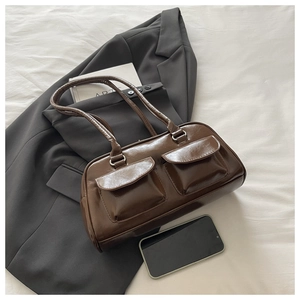 Close-up of a dark brown glossy PU leather underarm bag with double front flap pockets