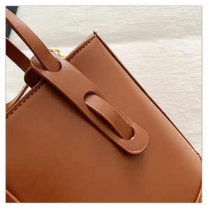Gros plan détaillé d'un sac à main en cuir marron avec boucle de sangle unique
