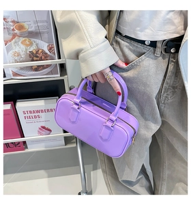 Detailed view of a purple PVC jelly boston bag with glossy finish and metal zippers