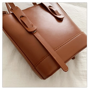 Détail rapproché d'un sac en cuir PU marron avec anneaux et coutures précises