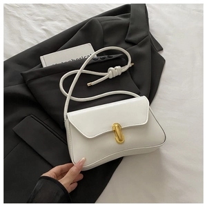 Close-up of minimalist white leather handbag with elegant gold capsule metal buckle