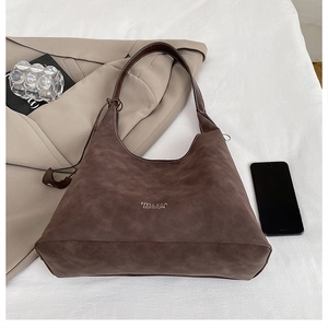 Dettaglio borsa Hobo in pelle scamosciata marrone con scritte bianche London