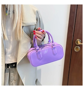 Detail of bright purple jelly pillow bag with shiny PVC finish and gold metal rings