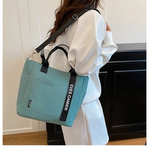 Adjustable shoulder strap and side webbing detail of the blue canvas lunch tote bag