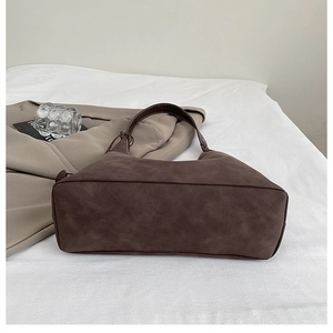 Dettaglio di una borsa tote vintage marrone scuro in pelle scamosciata opaca