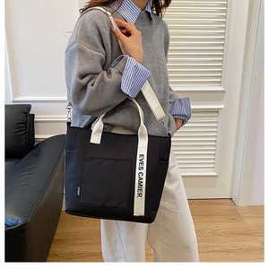 Detail of black canvas lunch tote bag with white straps and detachable shoulder strap