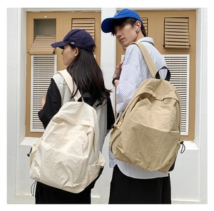 Close-up of minimalist nylon backpacks featuring drawstring side pockets and large front compartments