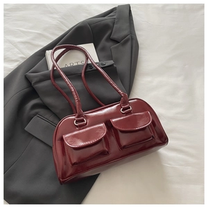 Detail of dark burgundy glossy faux leather shoulder bag with double front flap pockets