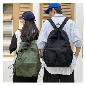Detailed side view of military green and black large backpacks with drawstring pockets