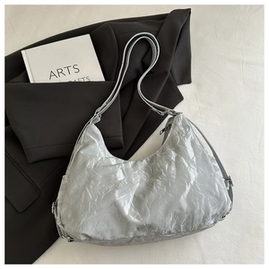 Detail of silver pleated texture on a large tote bag with metallic finish and strap