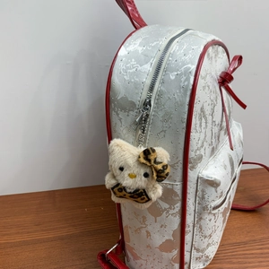 White marble pattern backpack with red accents and small silver studs from a 45-degree angle