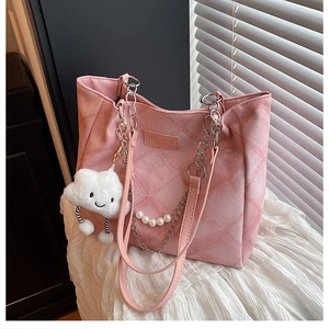 Close-up of pink quilted denim tote bag with pearl strap and plush cloud charm