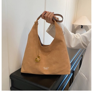 Dettaglio della borsa Hobo in camoscio color cuoio con logo bianco e anelli metallici