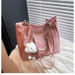 Close-up of pink quilted tote bag featuring pearl chain and white cloud plush pendant