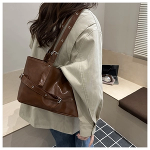 Brown retro leather tote bag with buckle details shown on model shoulder for daily commute