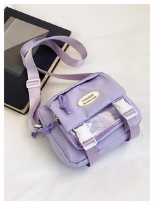 Detail of light purple nylon crossbody bag with white buckle and transparent mesh pocket