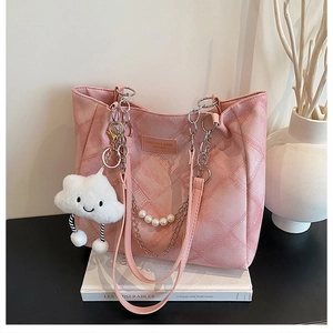 Detail view of pink quilted tote bag with silver chain, pearl strap and cloud charm