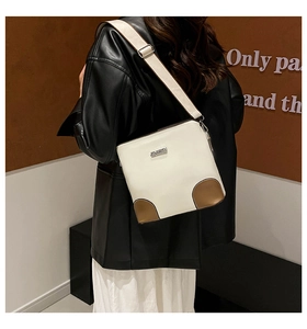 Detail of adjustable wide fabric strap and contrast leather corner on bucket bag