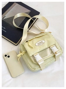 Detail view of yellow nylon crossbody bag with transparent mesh pocket and buckle