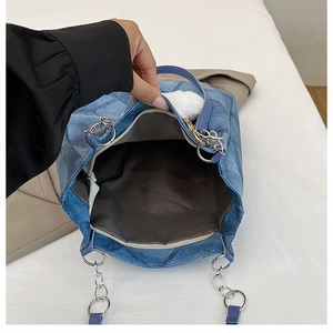 Top view of blue denim tote bag showing spacious brown interior and silver chain strap