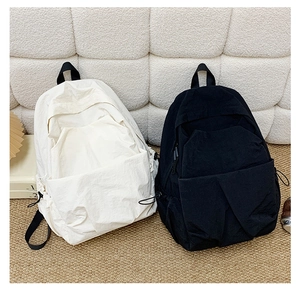 Detail view of large capacity nylon backpacks in cream and black for daily commute