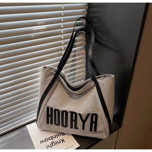 Detailed macro view of the minimalist HOORYA canvas tote bag with black leather trim detail