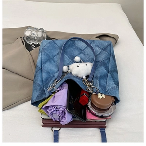 Interior view of quilted denim tote bag showing storage for umbrella, phone, and cosmetics
