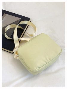 Detail view of the soft nylon fabric and adjustable wide strap of this pastel messenger bag