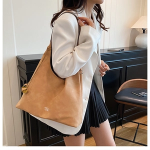 Dettaglio della borsa tote in pelle scamosciata color cammello con logo stampato