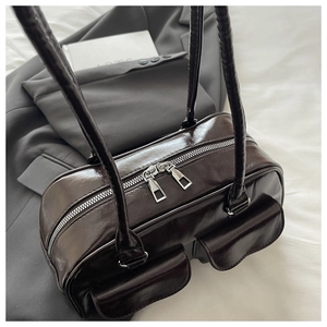 Detail of vintage chocolate brown tote bag with dual silver zippers and front pockets