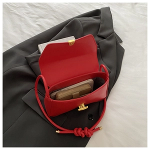 Detail of red leather shoulder bag showing internal capacity for wallet and phone