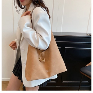 Dettaglio della borsa tote color cammello con coulisse e pendente a sfera dorata