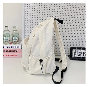 Detail of off-white backpack featuring side drawstring pocket and black nylon straps