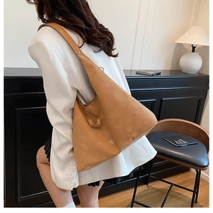 Dettaglio della borsa hobo in pelle scamosciata caramello con ampio spallaccio