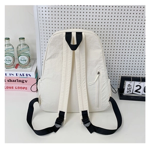 Rear view of white nylon backpack with black adjustable straps and a side zip pocket