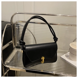 Detail of black leather handbag featuring gold twist lock and unique knotted shoulder strap