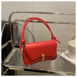 Detailed view of the bright red leather handbag with a stylish gold rectangular swivel lock