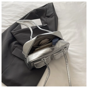 Detailed internal compartments of silver shoulder bag showing storage for cosmetics