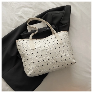 Détail du sac cabas blanc avec imprimés papillons noirs et texture plissée en relief