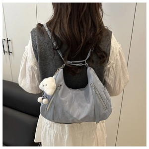Light blue nylon tote bag worn by a person, featuring a cute plush sheep charm