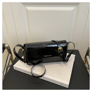 Detail of glossy black patent leather shoulder bag with gold KEKEDOU & BAG lettering