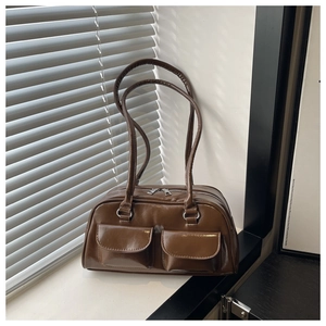 Detail of brown PU leather shoulder bag featuring dual front flap pockets and silver zippers