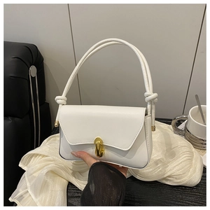 Detail of white leather handbag featuring a gold twist lock and unique knotted strap