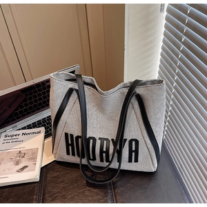 Close-up of Hoorya canvas tote bag showing black leather handles and printed logo