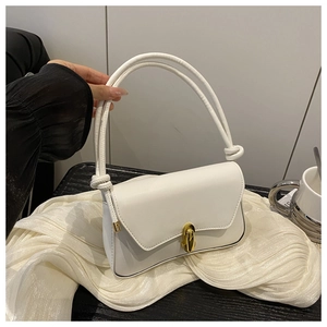 Detail of white leather shoulder bag with gold turn-lock and knotted handles on fabric
