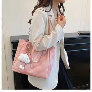 Pink quilted tote bag with pearl chain strap and plush cloud charm detail in side view