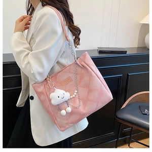Detailed close-up of a pink quilted tote bag featuring silver chain and pearl accents