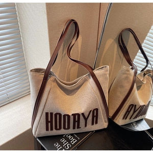 Mirror view showing detail of canvas tote bag with HOORYA lettering and brown leather strap